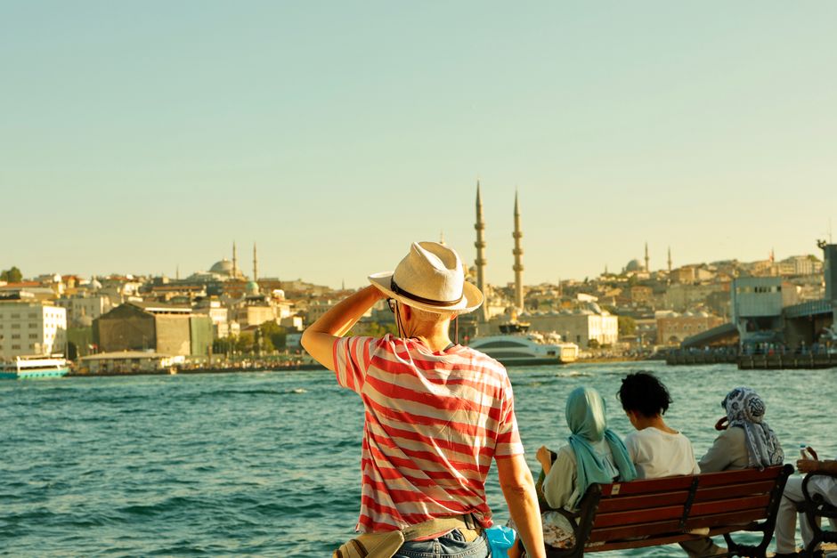 A tourist enjoys the Istanbul skyline across the Bosphorus, capturing historic architecture.